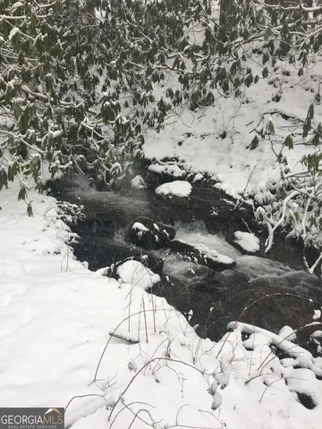 a view of white house with a yard covered in snow