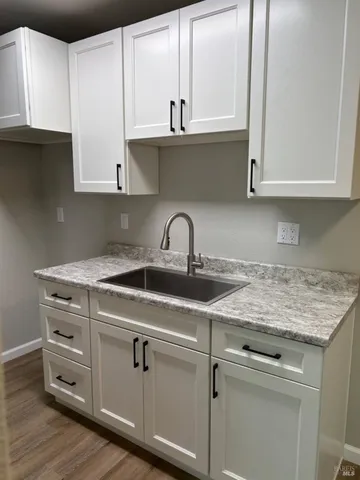 a kitchen with granite countertop a sink and cabinets