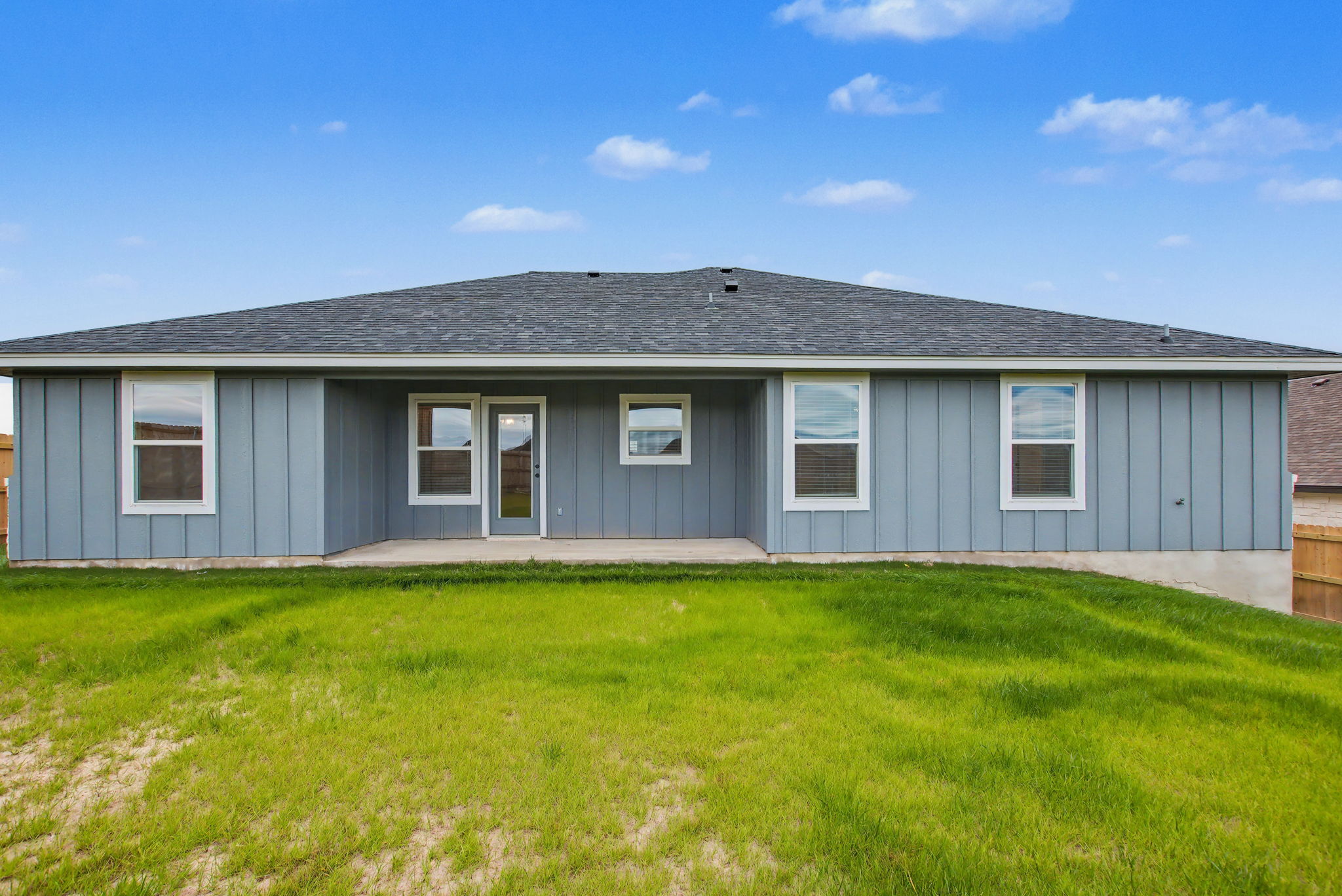 206 Water Wl Road Burnet, TX 78611 - Photo 23 of 25 Board and batten siding pairs with a covered concrete patio overlooking the lawn.