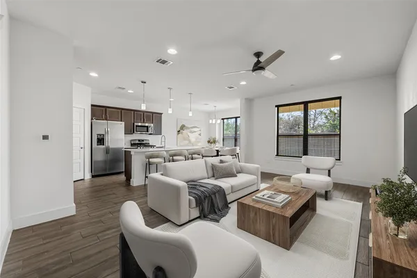 a view of a kitchen with kitchen island wooden floors appliances and a window