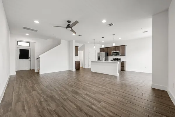 a living room with furniture kitchen and a large window