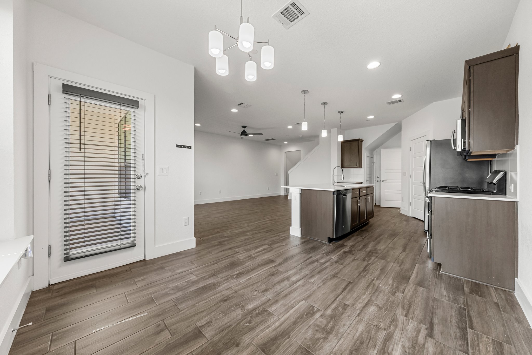 12315 Maypole Bend, Unit 1002 Austin, TX 78717 - Photo 28 of 29 Kitchen with ceiling fan, open floor plan, stainless steel appliances, dark wood-style floors, and suspended lighting