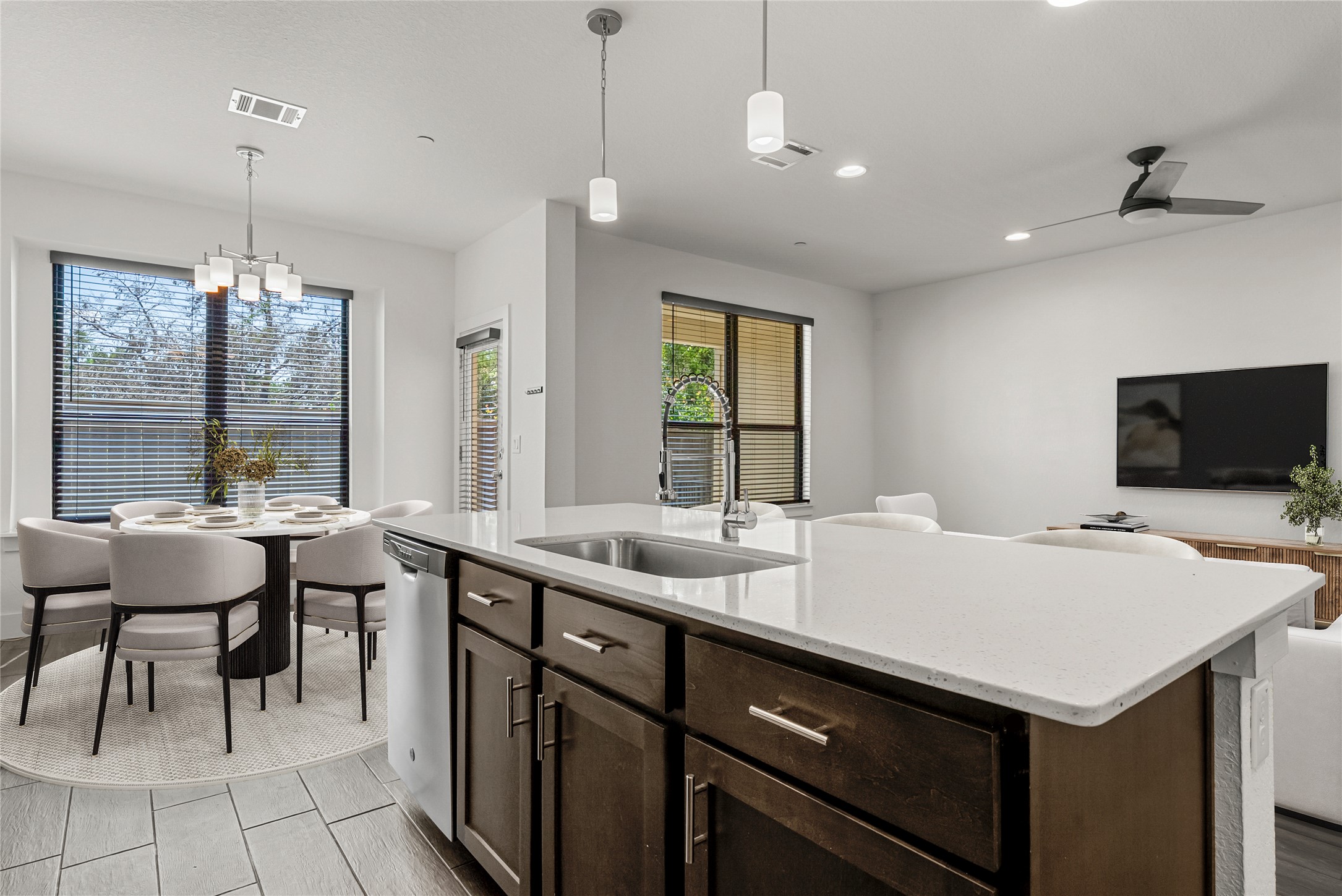 12315 Maypole Bend, Unit 1002 Austin, TX 78717 - Photo 29 of 29 Kitchen with dark wood finish cabinetry, light stone counters, open floor plan, a center island with sink, and dishwasher