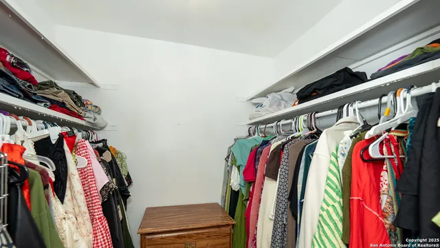 a view of walk in closet with clothes