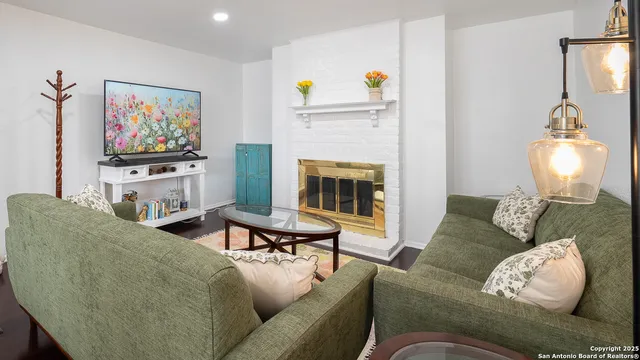 a living room with furniture a fireplace and a flat screen tv