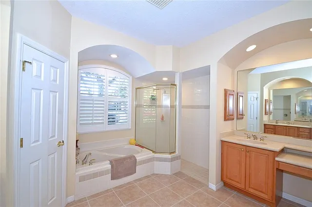 a spacious bathroom with a granite countertop sink a toilet a mirror and shower