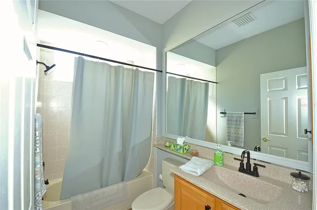 a bathroom with a sink vanity mirror and toilet