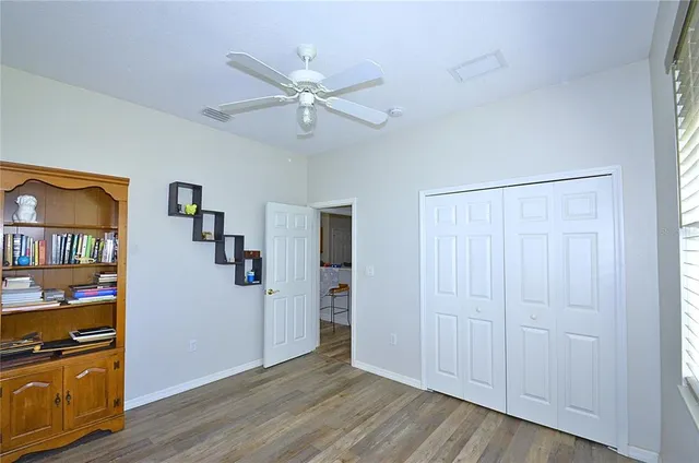 a view of a livingroom with wooden floor closet and windows