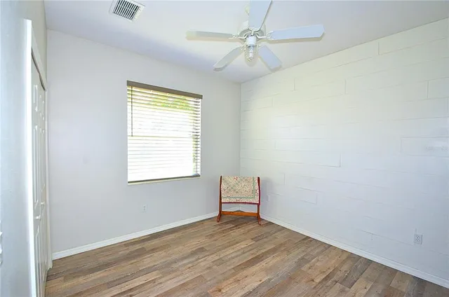 an empty room with a window and a fan