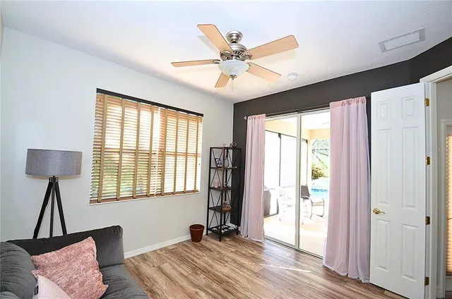 a workspace with wooden floor windows and a ceiling fan