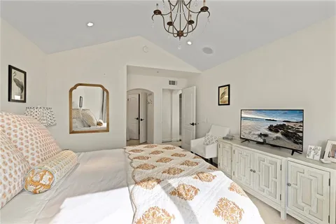 a bedroom with a bed and a flat tv screen on dresser