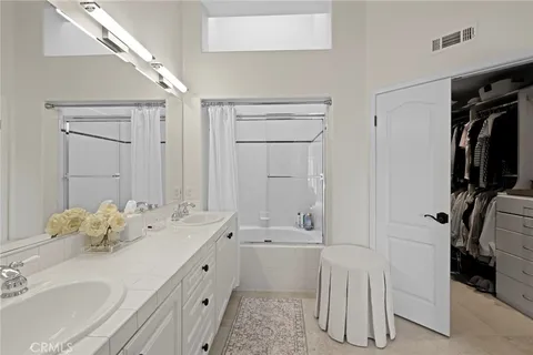 a en suite bathroom with a double vanity sink a mirror and shower