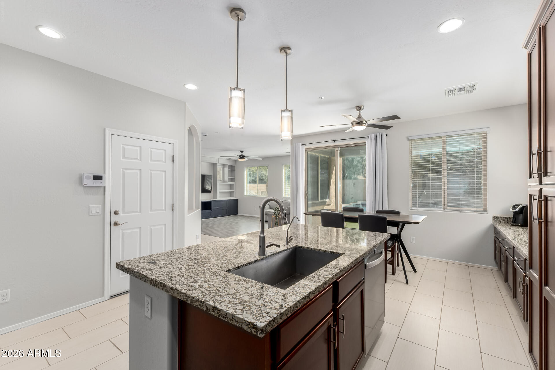 3469 East Indigo Street Gilbert, AZ 85298 - Photo 11 of 32 a kitchen with granite countertop a sink a counter top space and living room view