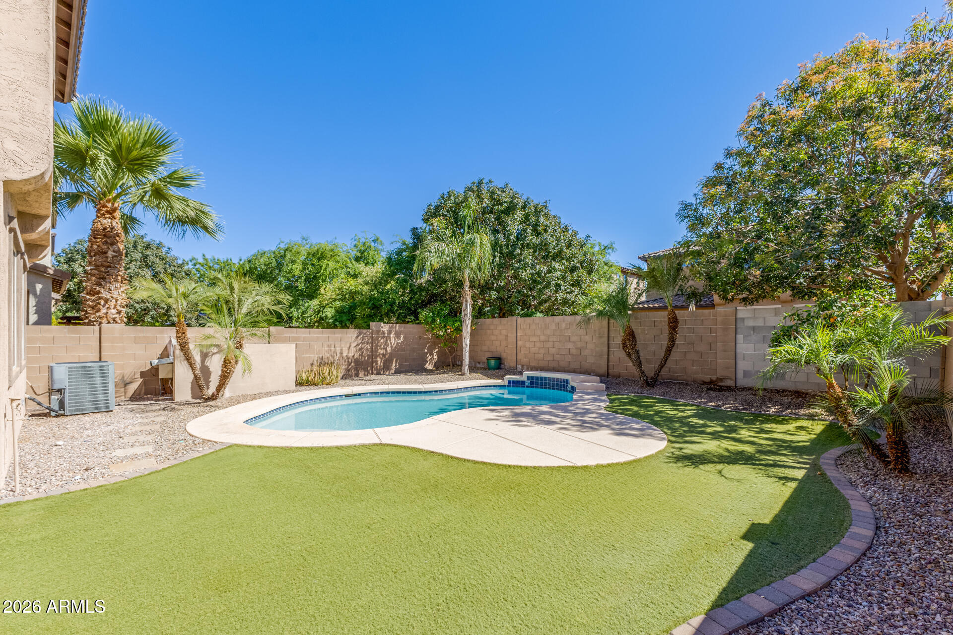3469 East Indigo Street Gilbert, AZ 85298 - Photo 30 of 32 a swimming pool with some trees in the background