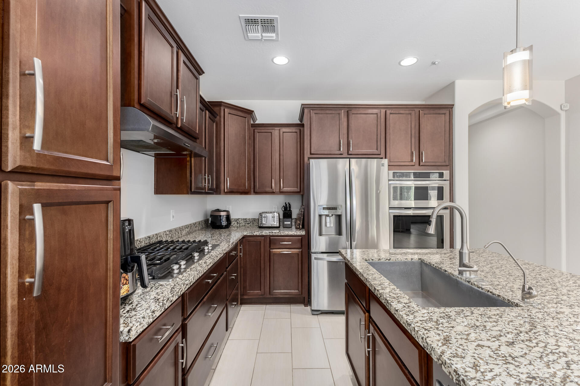 3469 East Indigo Street Gilbert, AZ 85298 - Photo 3 of 32 a kitchen with stainless steel appliances granite countertop a sink stove and refrigerator
