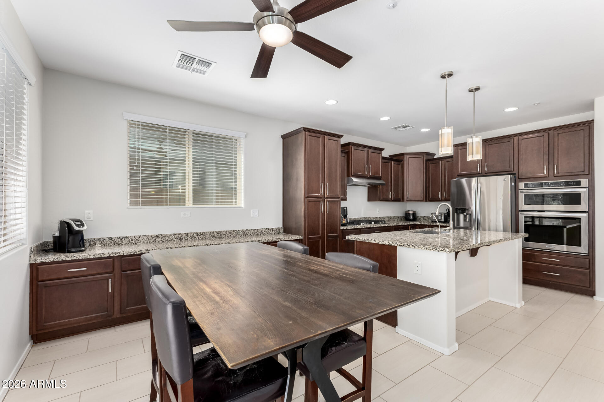 3469 East Indigo Street Gilbert, AZ 85298 - Photo 9 of 32 a kitchen with stainless steel appliances granite countertop a stove a sink a microwave a center island and a refrigerator