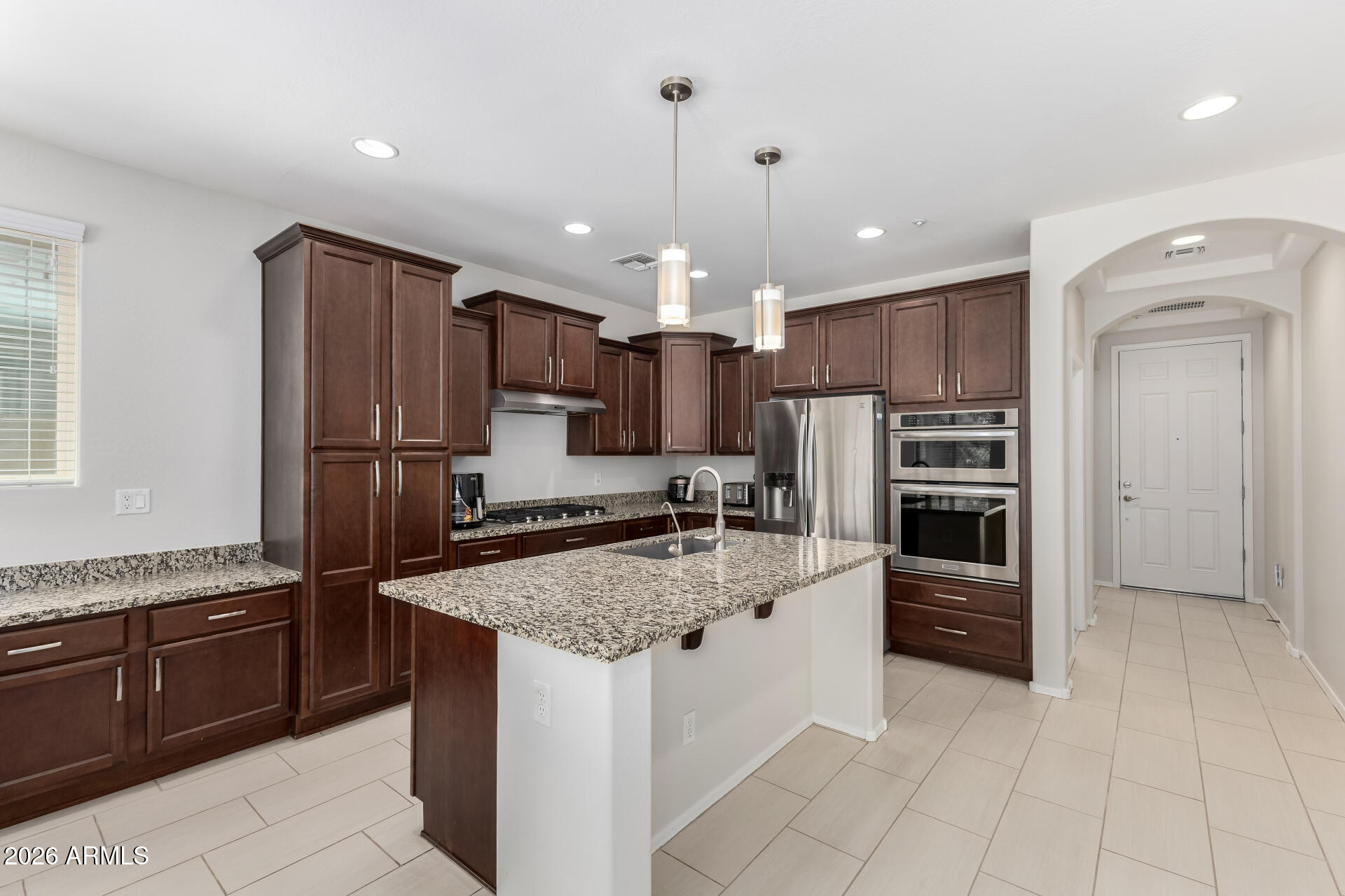 3469 East Indigo Street Gilbert, AZ 85298 - Photo 10 of 32 a kitchen with granite countertop a refrigerator and a sink