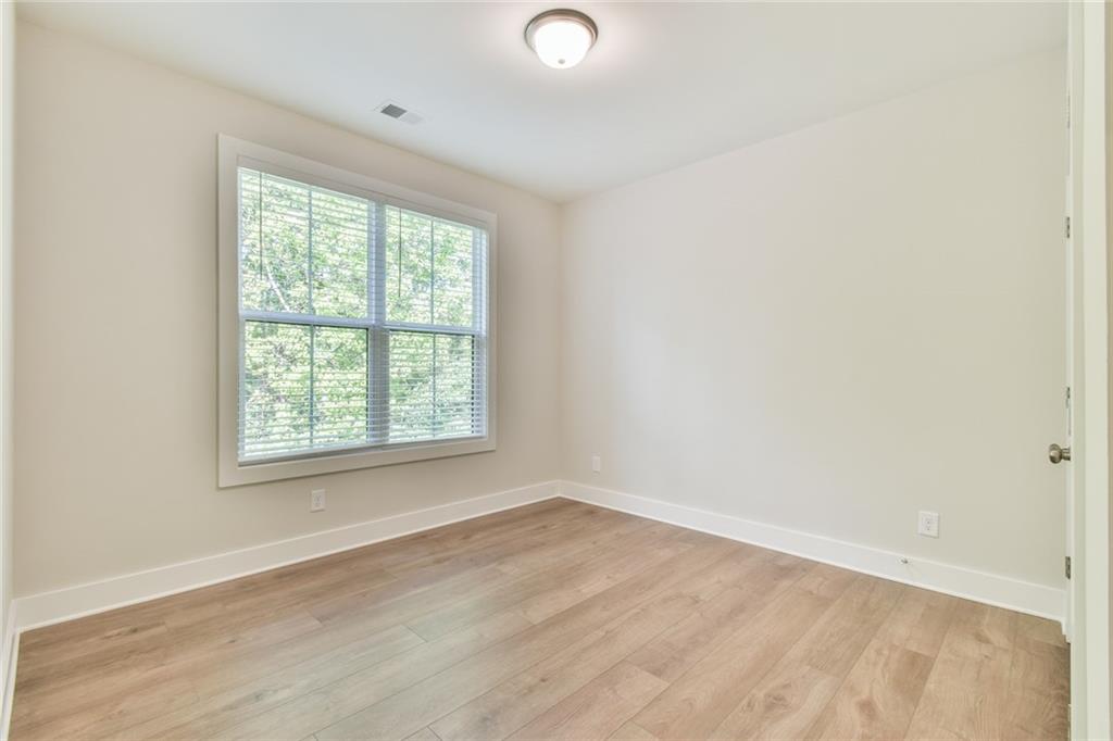 235 Firefly Circle Alpharetta, GA 30009 - Photo 18 of 30 an empty room with wooden floor and windows