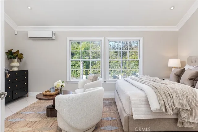 a bedroom with a bed and large windows