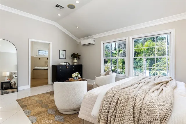 a bedroom with a bed and large windows