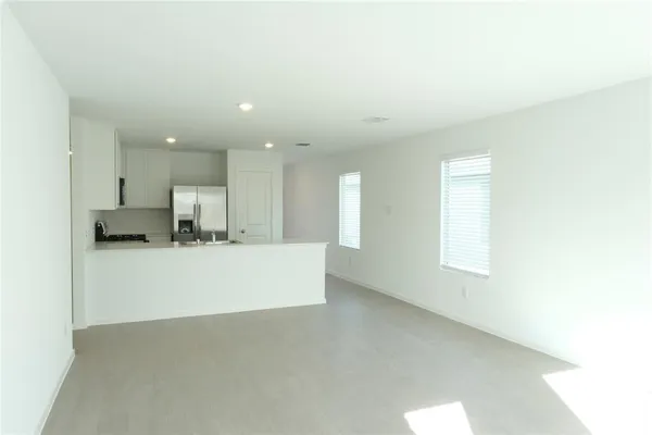 a view of kitchen with kitchen island a sink wooden floor and a refrigerator