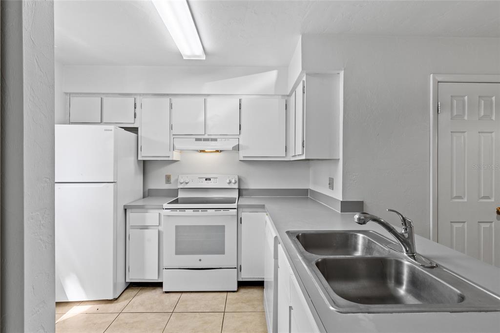 2219 Southwest 39th Way Gainesville, FL 32607 - Photo 6 of 17 a kitchen with white cabinets sink and white appliances