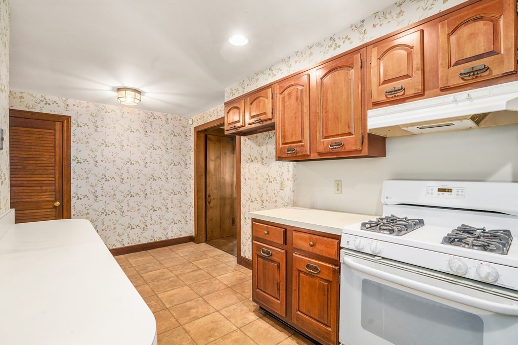 61 Walnut Street Shrewsbury, MA 01545 - Photo 2 of 38 a kitchen with stainless steel appliances granite countertop a refrigerator a stove and white cabinets with wooden floor
