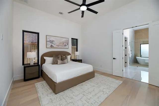 a bedroom with a large bed and ceiling fan