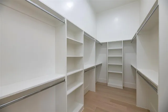 a view of walk in closet with empty racks