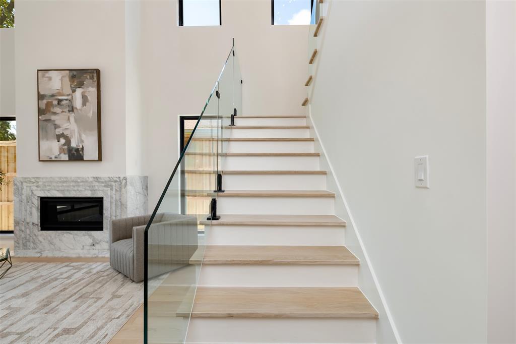 6038 Prospect Avenue Dallas, TX 75206 - Photo 19 of 40 a view of staircase with white walls and a fireplace