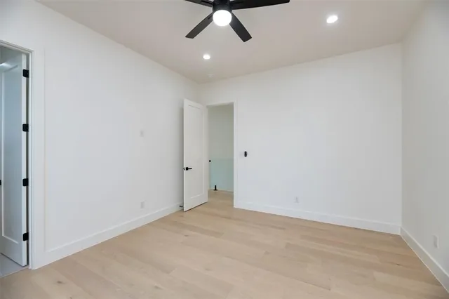 an empty room with a ceiling fan and carpet