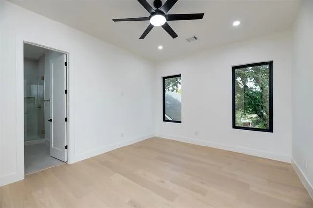 an empty room with fan and windows