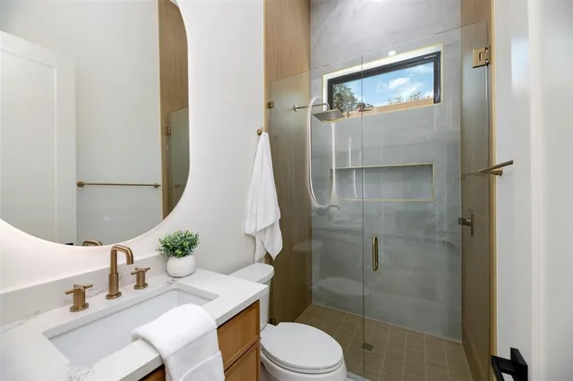 a bathroom with a sink vanity mirror and toilet