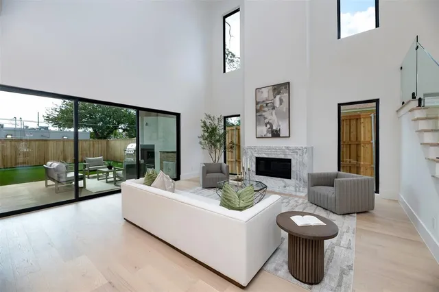 a living room with furniture a fireplace and a floor to ceiling window