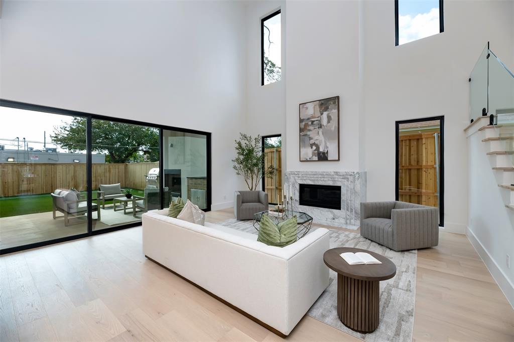 6038 Prospect Avenue Dallas, TX 75206 - Photo 7 of 40 a living room with furniture a fireplace and a floor to ceiling window