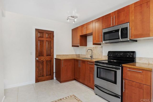 a kitchen with stainless steel appliances granite countertop a stove microwave and sink
