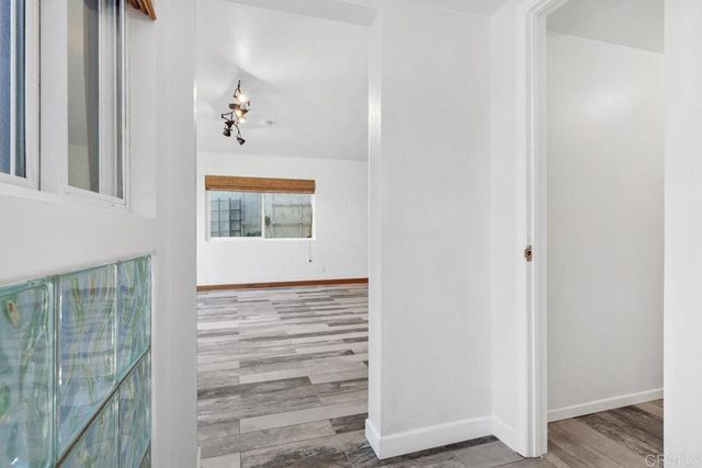 a view of a hallway with wooden floor and a window