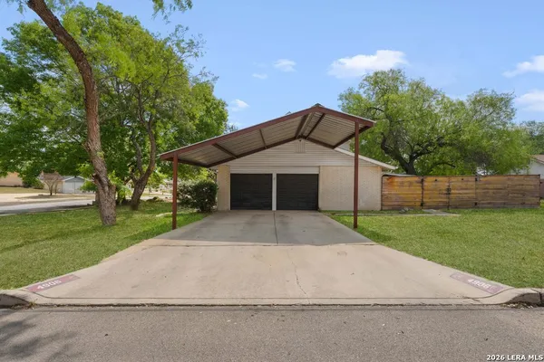 a front view of a house with a yard and trees