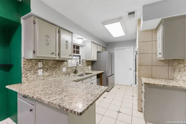 a kitchen with stainless steel appliances granite countertop a refrigerator sink and cabinets