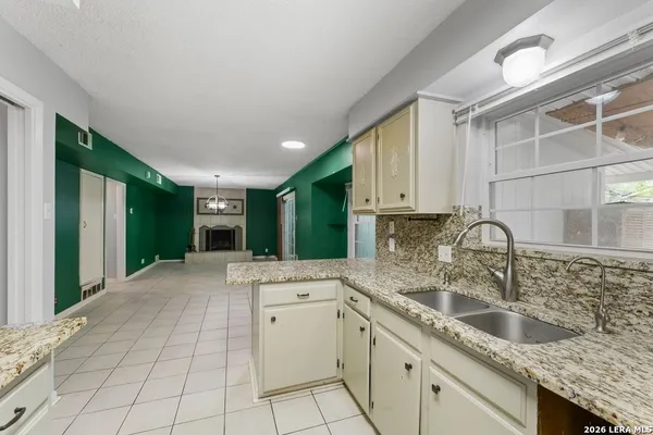 a kitchen with white cabinets and stove