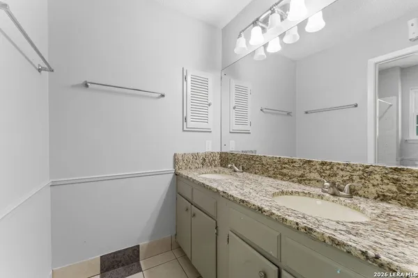 a bathroom with a granite countertop sink and a mirror