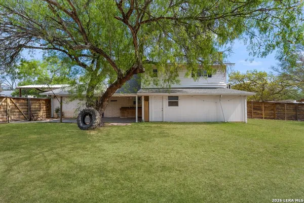 a view of a house with a large tree and a big yard