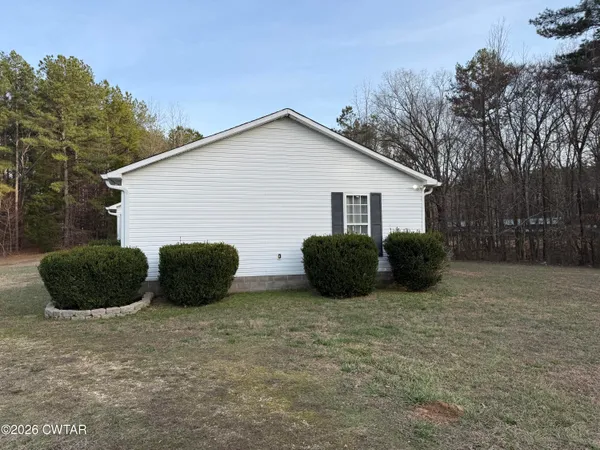 a view of a house with a yard and large tree