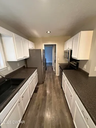 a kitchen with a sink a counter top space and stainless steel appliances