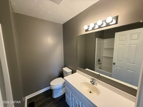 a bathroom with a sink a toilet a light fixture and a mirror
