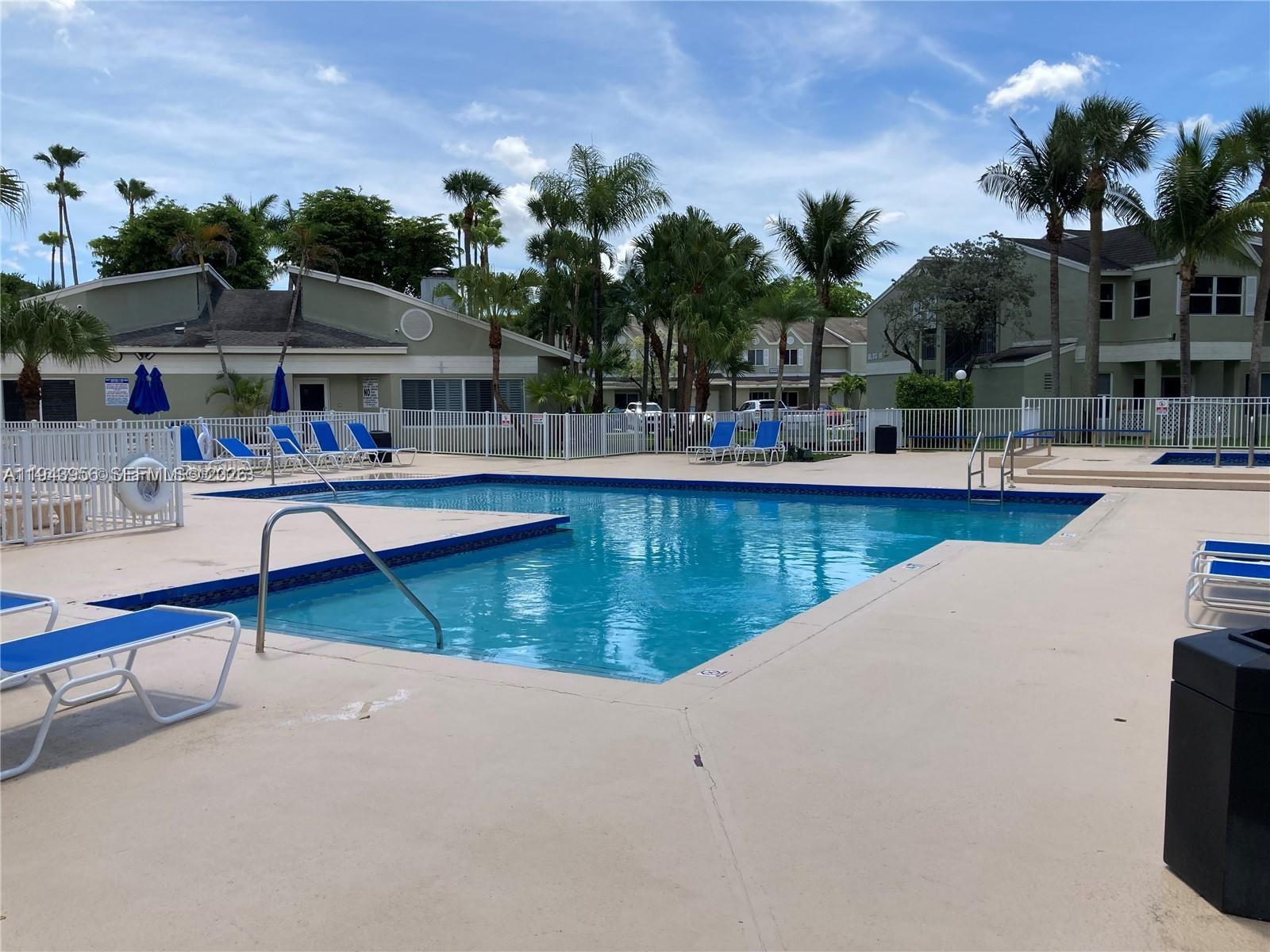17320 Northwest 67th Place, Unit N7 Hialeah, FL 33015 - Photo 3 of 4 a view of a swimming pool with lounge chairs