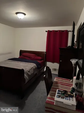 a bedroom with a bed and a black mirror