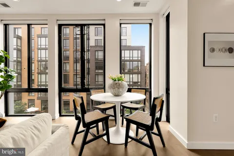 a view of a dining room with furniture large windows and wooden floor