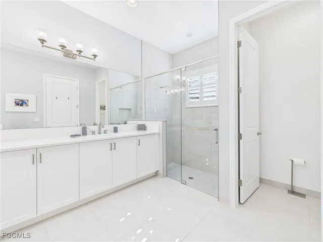 a spacious bathroom with a shower a sink and mirror