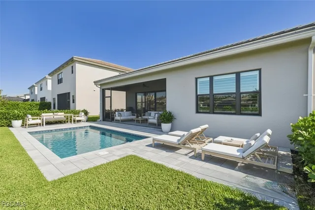 a view of a house with swimming pool and sitting area